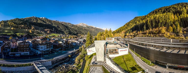 A panoramic view of a mountain town with modern buildings and a hotel on the slopes of St Anton.